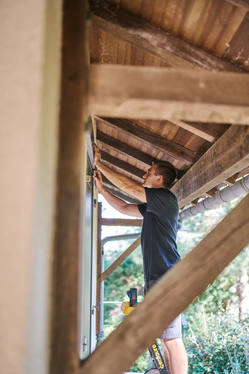 Un artisan travaille sous une charpente en bois, photographie du studio